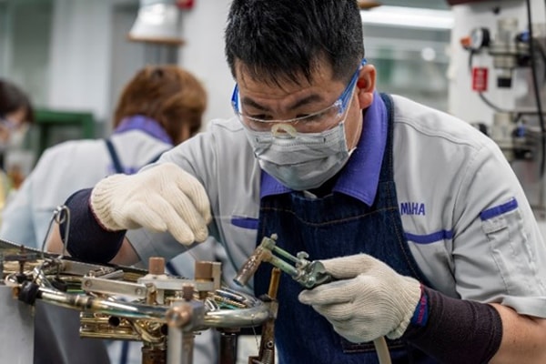 Řemeslník pájící kovové díly bezolovnatou pájkou.