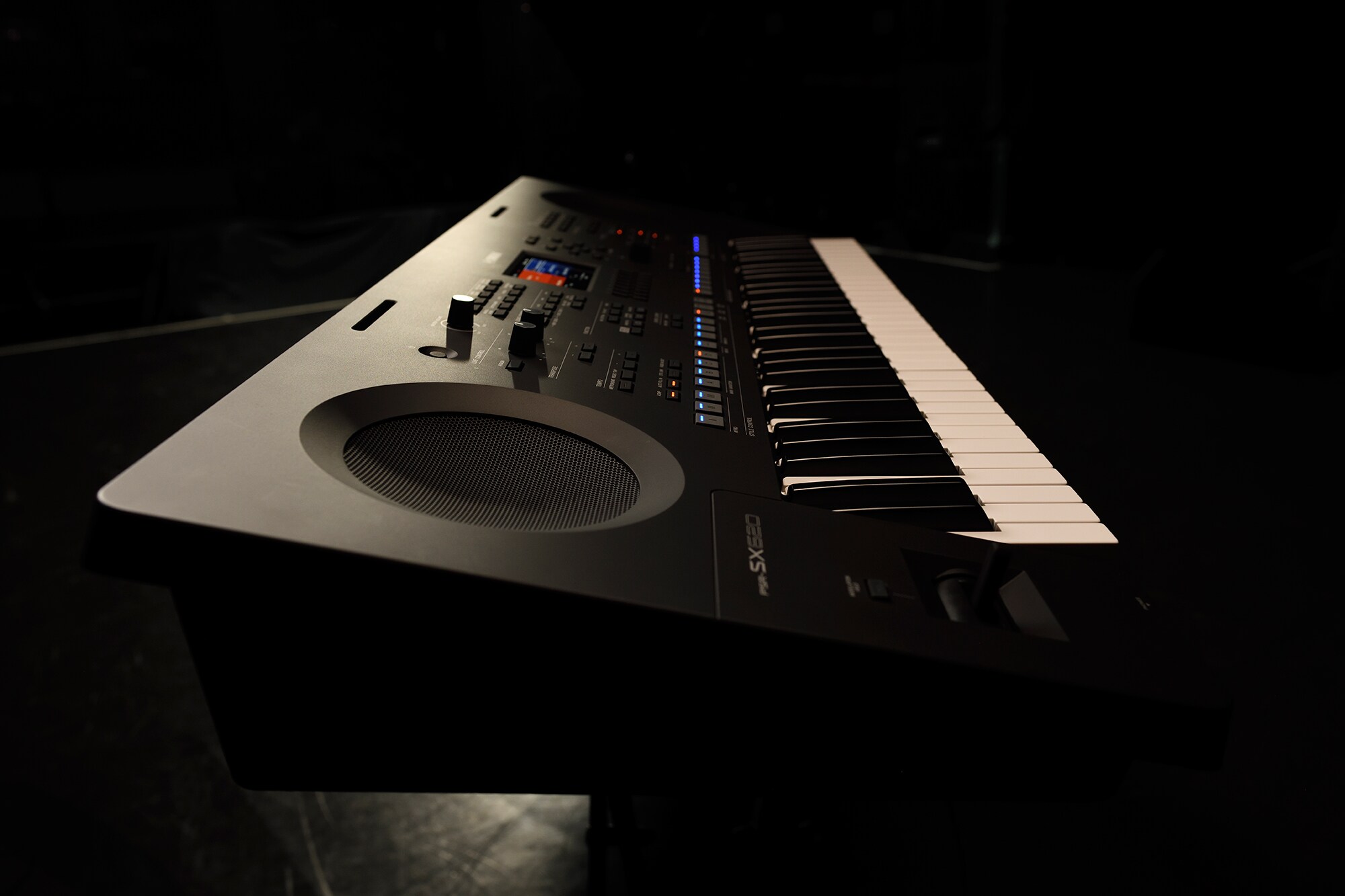 Keyboard na stojanu v záři pódiových reflektorů