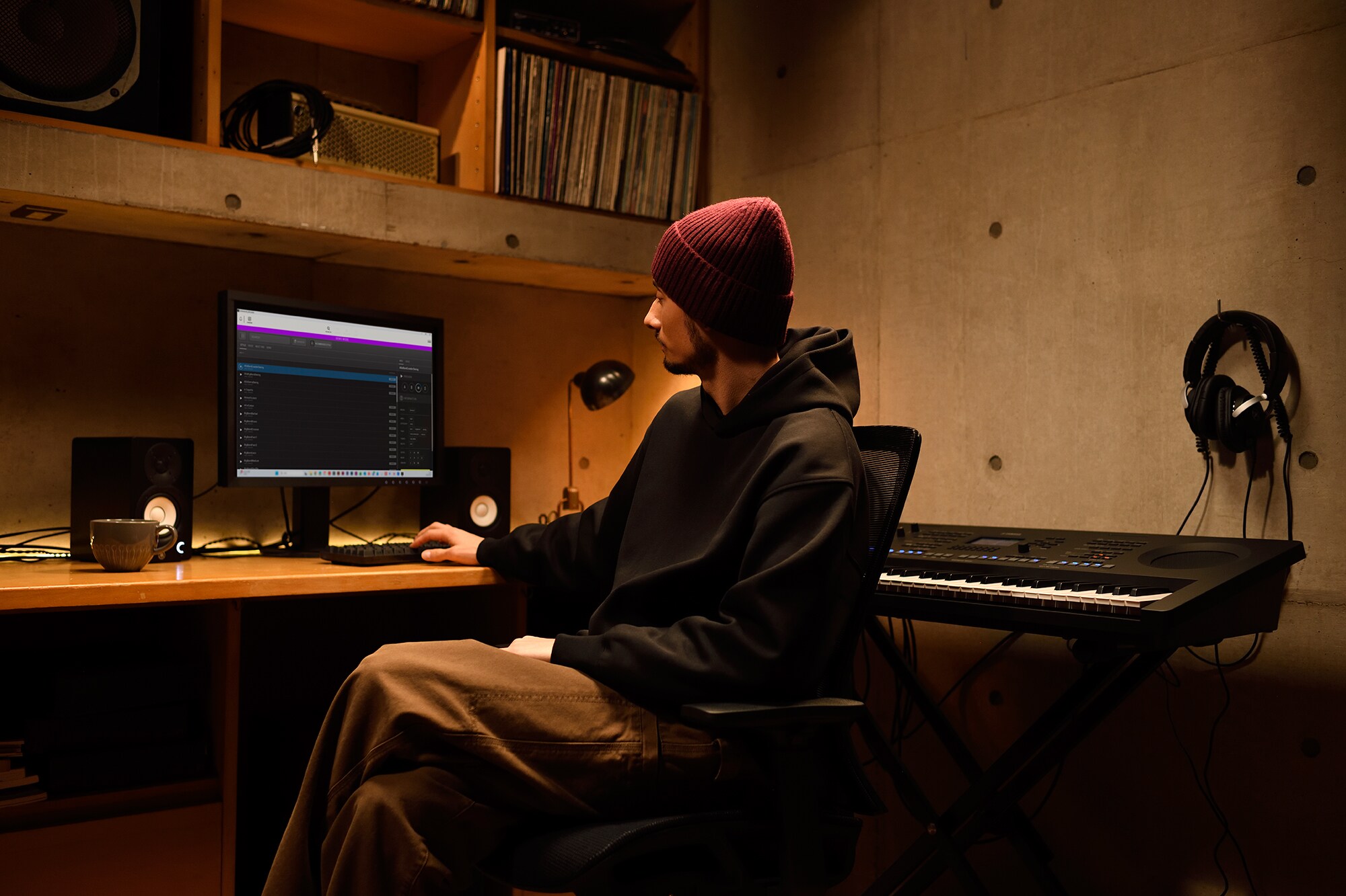 Domácí hudební pracoviště s počítačem a keyboardem, na kterém pracuje klávesista ve svém domácím studiu