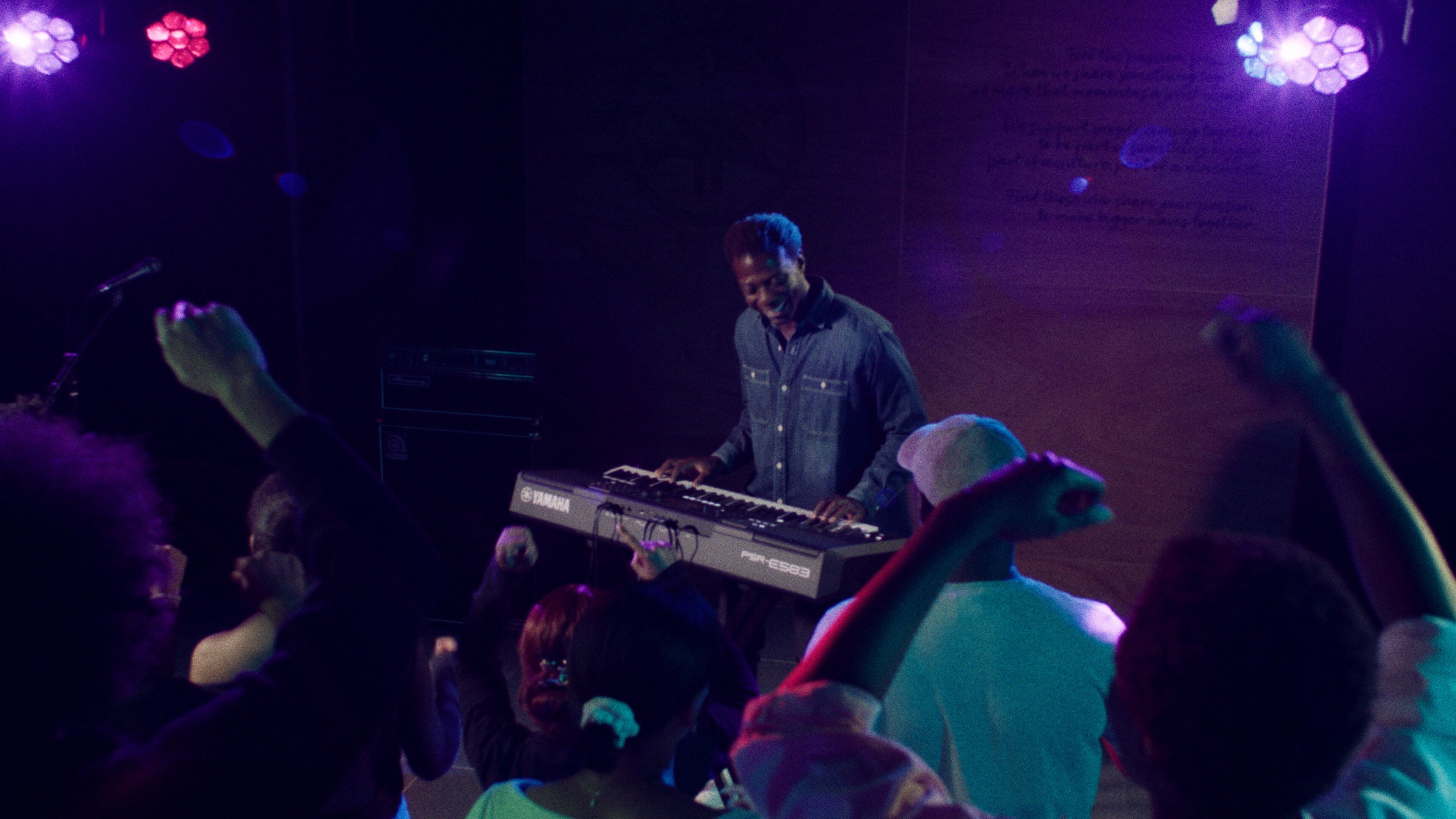 Osoba hrající na přenosné klávesy PSR-E583 se sluchátky