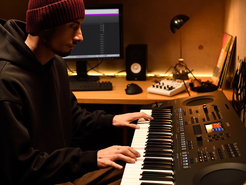 Člověk hrající na keyboard PSR-SX620 v domácím studiu.