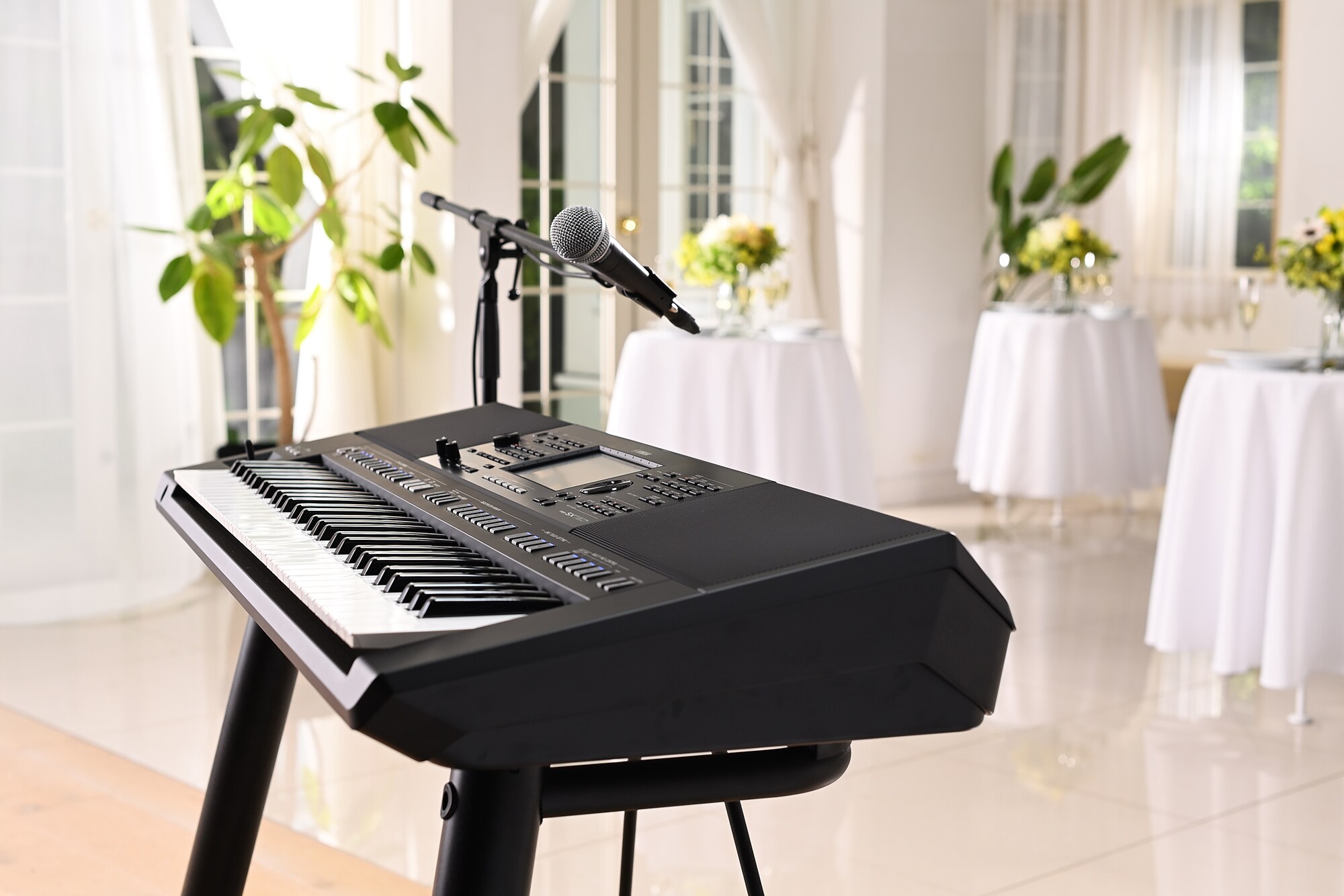 Aranžovací pracovní stanice Yamaha PSR-SX720+ s mikrofonním stojanem v prostorách pro pořádání večírků