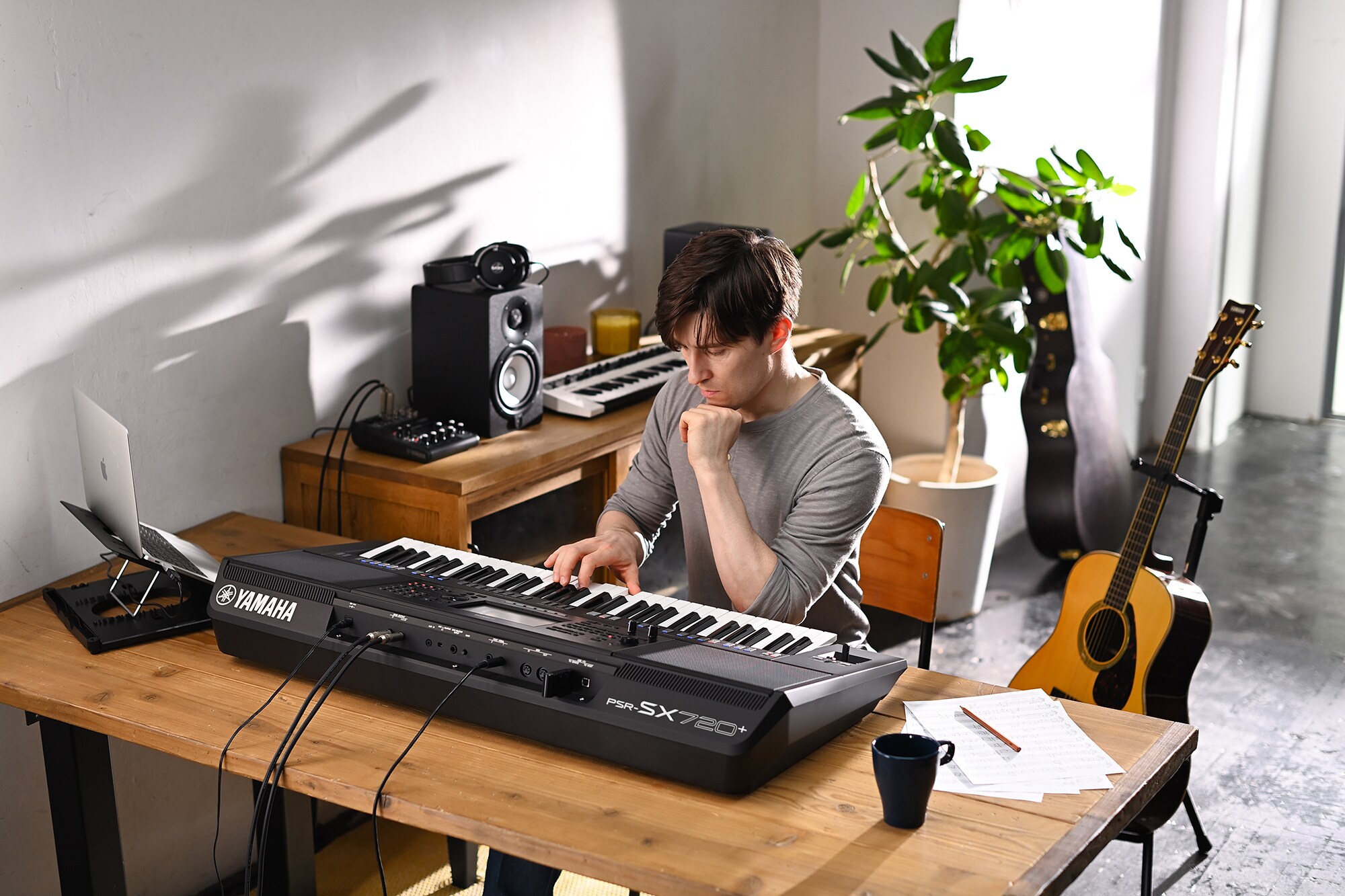 Fotografie osoby hrající na aranžovací pracovní stanici Yamaha PSR-SX720+