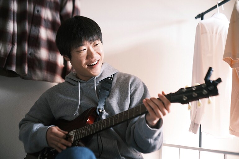 Muž, který se poprvé pokouší hrát na kytaru